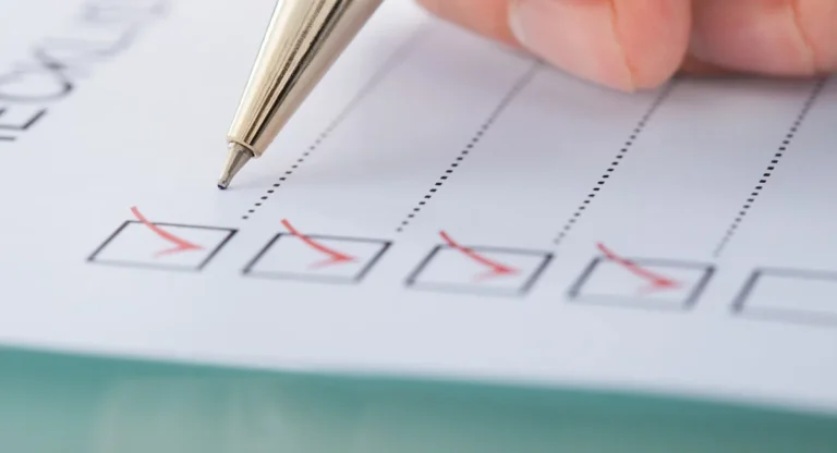 image of a hand holding a pen and checking off items on a checklist