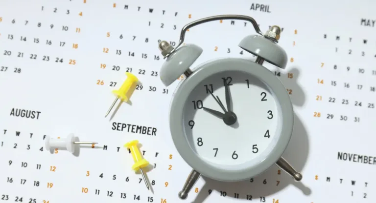 paper calendar with an alarm clock over the month of october